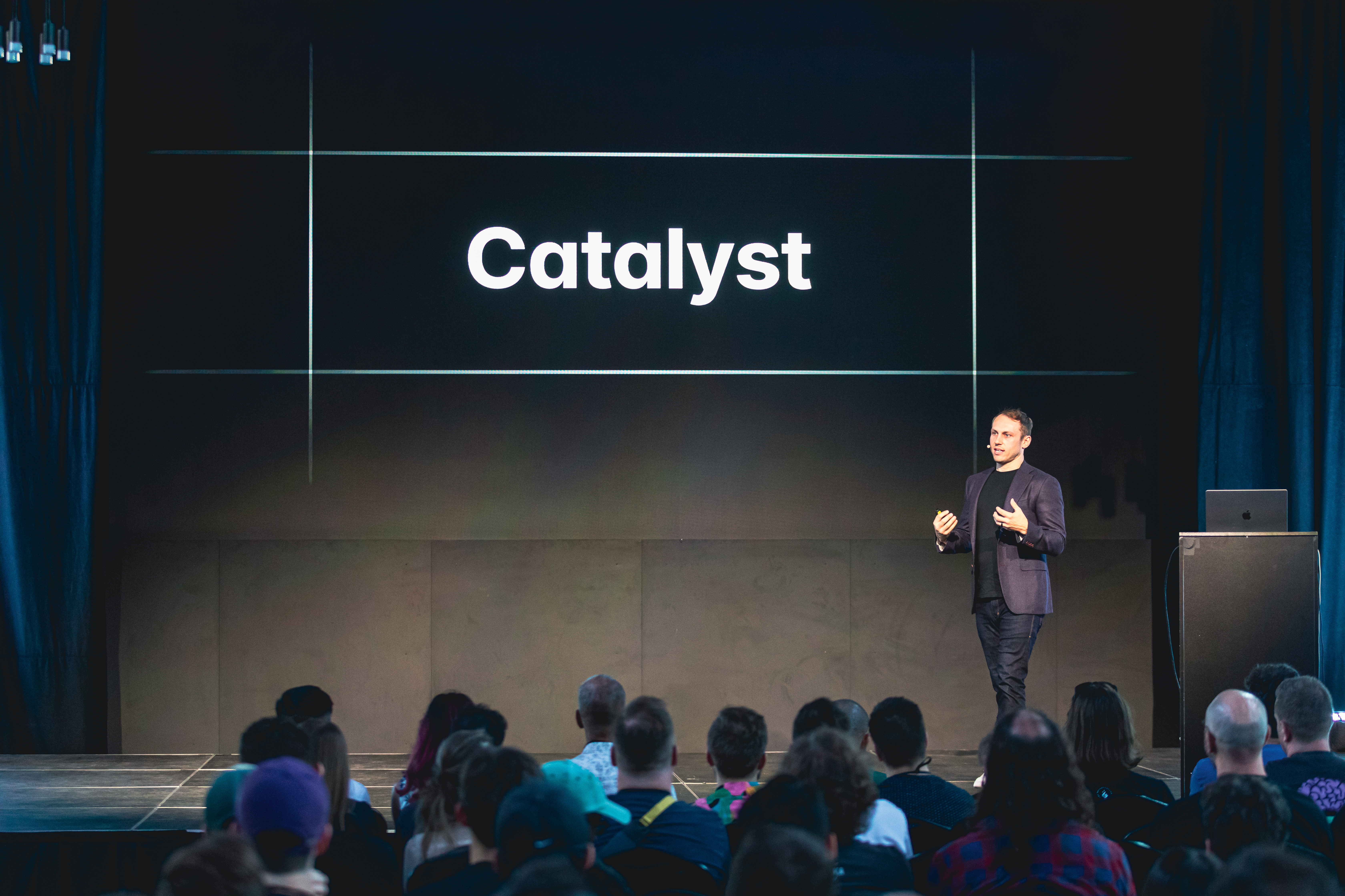 Adam Wathan en el escenario frente a una diapositiva que dice Catalyst